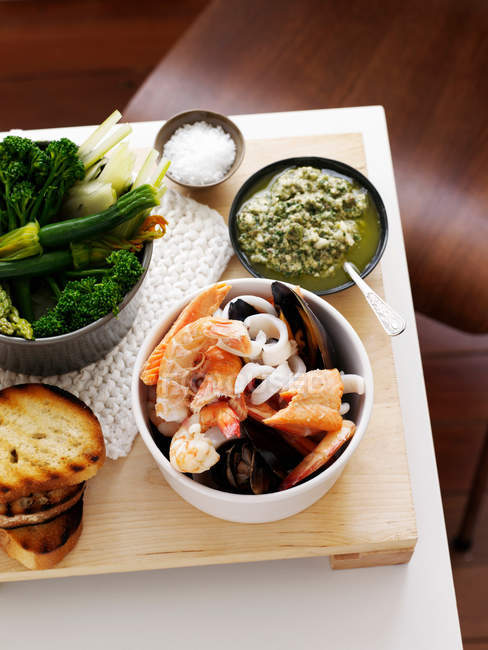 Dish of seafood with grilled bread and vegetables — Stock Photo