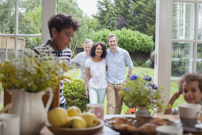 Family coming in for breakfast after walk in garden — Stock Photo