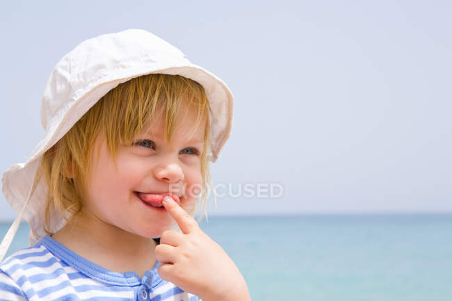 Portrait de bébé à la plage avec la langue sortie — Photo de stock