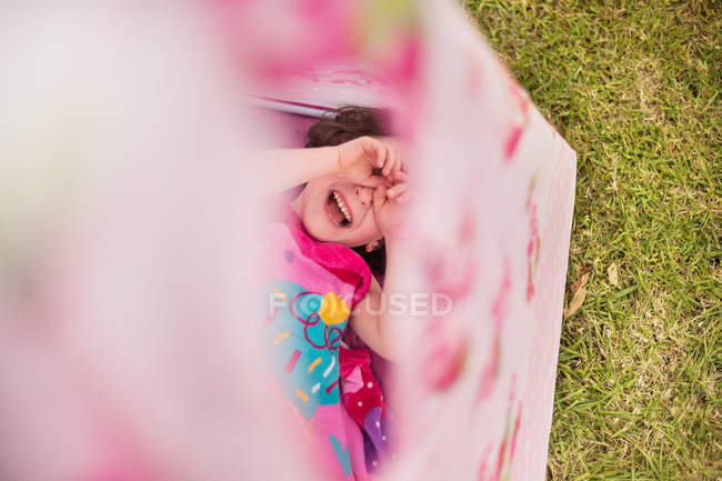 Vista aérea de la chica en tipi, las manos cubriendo los ojos sonriendo - foto de stock