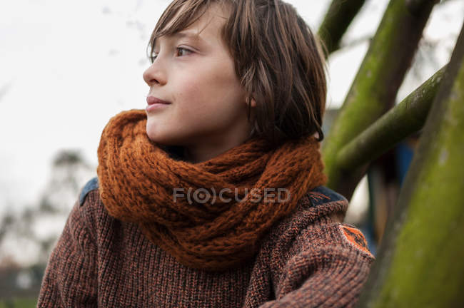 Мальчик в шарфе, отводящий взгляд — стоковое фото