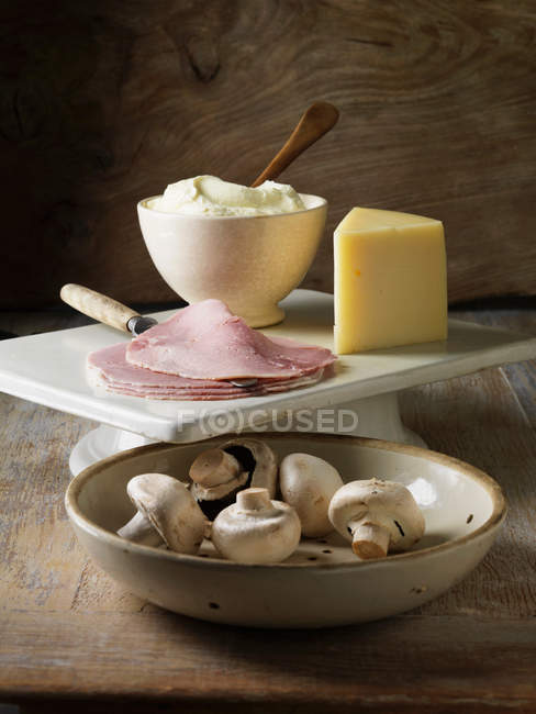 Mushrooms, ham and cheese on board — Stock Photo