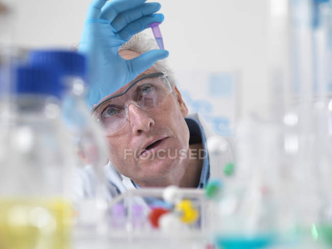 Primo piano dello scienziato con in mano una fiala contenente un campione di DNA — Foto stock