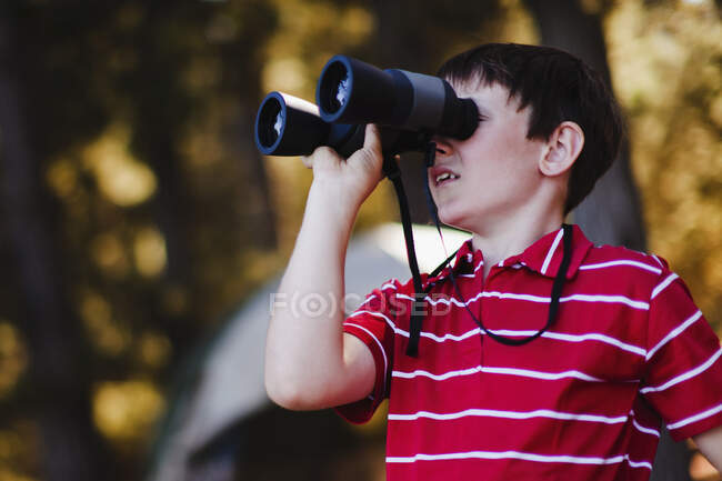 Menino usando binóculos no parque de campismo — Fotografia de Stock
