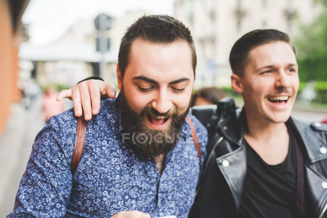 Amici maschi che camminano sul marciapiede insieme — Foto stock