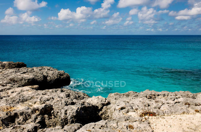 Скелі і спокійне море з хмарним небом — стокове фото