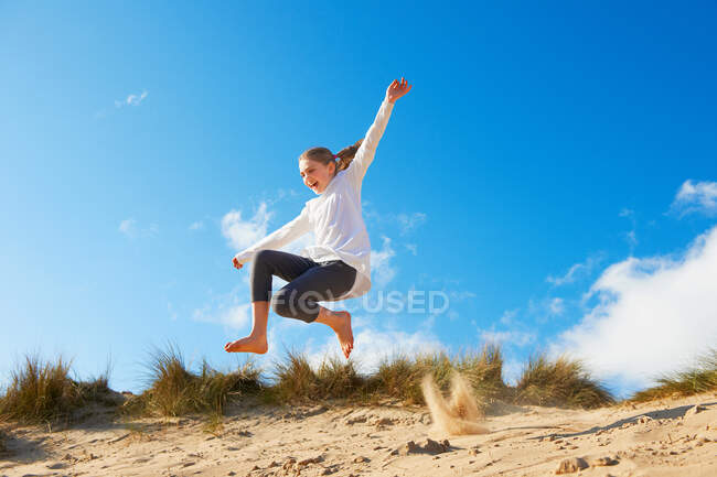 Дівчина стрибає на пляжі — стокове фото