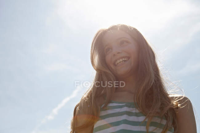 Chica sonriendo bajo caliente día soleado - foto de stock