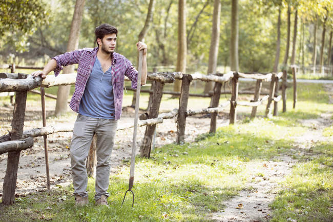 Young male farmer leaning against paddock fence, Premosello, Verbania, Piemonte, Italy — Stock Photo