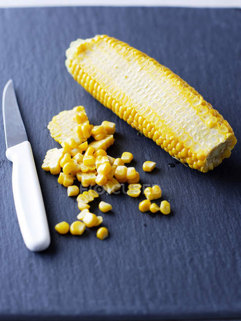 Boiled corn and knife — Stock Photo