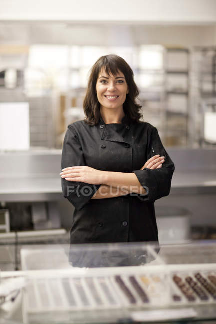 Portrait de femme dans la cuisine commerciale avec les bras croisés — Photo de stock