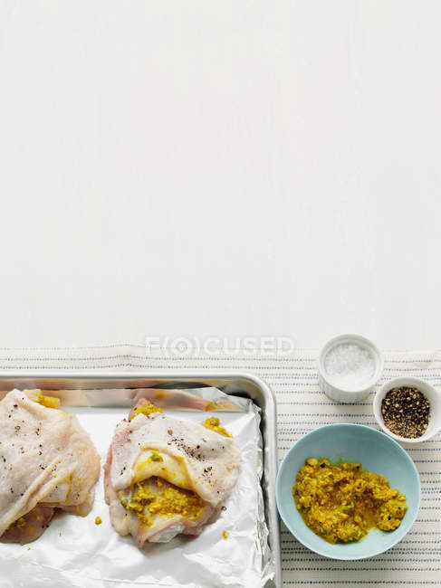 Chickens with marinade on metal baking tray — Stock Photo