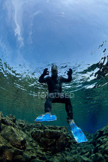 Taucher schwimmt durch Felsformationen — Stockfoto