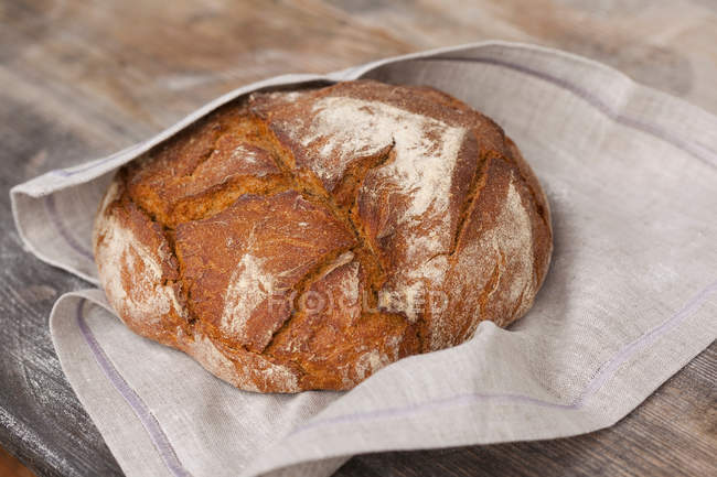 Pane appena sfornato di pane di pasta madre su tovagliolo di stoffa — Foto stock