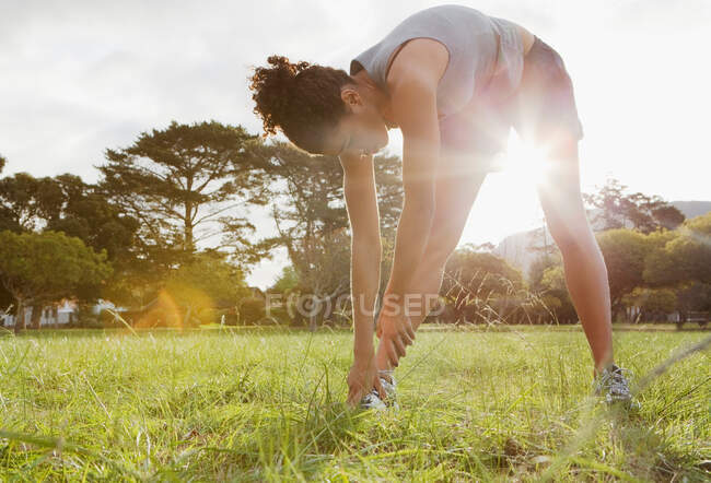 Läufer dehnt sich im Feld — Stockfoto