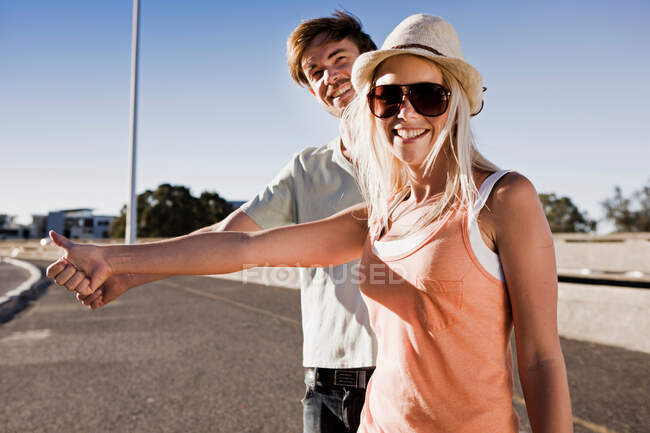 Young couple hitch hiking — Stock Photo