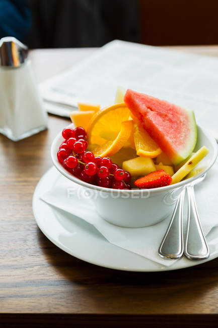 Tazón de ensalada de frutas servido en la mesa - foto de stock