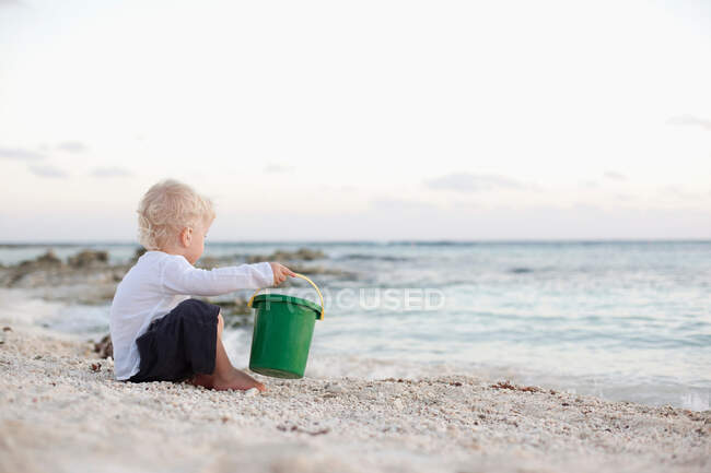 Toddler boy playing with sand on beach — Stock Photo