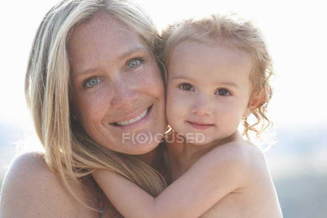 Portrait of mother hugging young daughter — Stock Photo