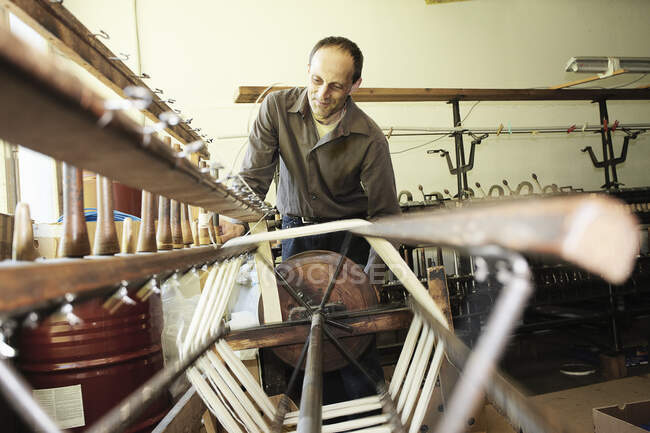 Рабочий, использующий ткацкий станок на шерстяной фабрике — стоковое фото