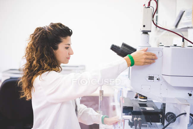 Жінка-вчена, що використовує спектрофотометр FTIR, фокусує зразок на мікроскопній камері , — стокове фото