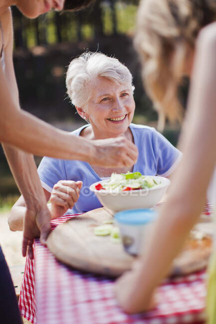 Older woman sitting at picnic table — Stock Photo