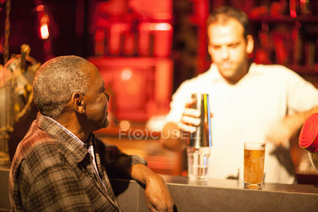 Homem sênior conversando com barman no bar de coquetéis Rio de Janeiro, Brasil — Fotografia de Stock