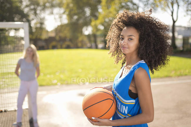 Portrait of young woman holding basketball — Stock Photo