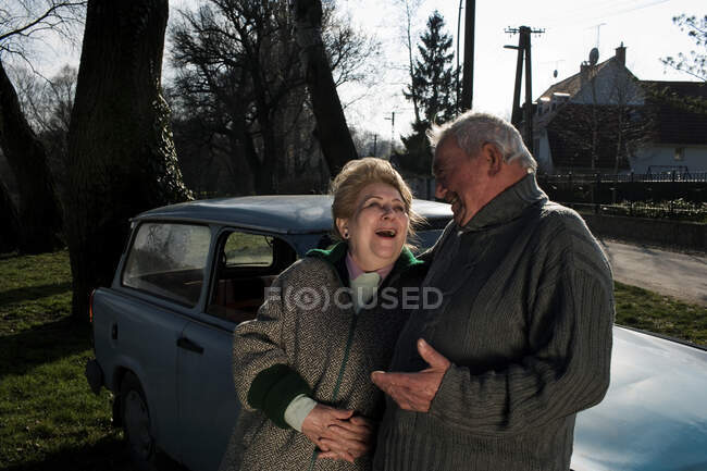 Seniorenpaar lehnt auf dem Land an Auto — Stockfoto