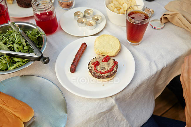 Hamburguesa con cara sonriente en ketchup - foto de stock