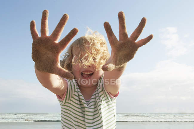 Menina segurando as mãos arenosas na praia, Camber Sands, Kent, Reino Unido — Fotografia de Stock