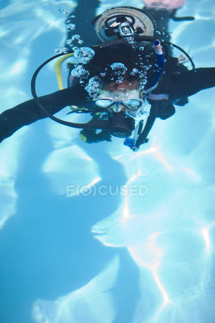 Jovem mergulhadora do sexo feminino treinando na piscina — Fotografia de Stock