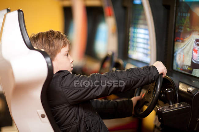 Garçon jouer sur le jeu vidéo de conduite — Photo de stock