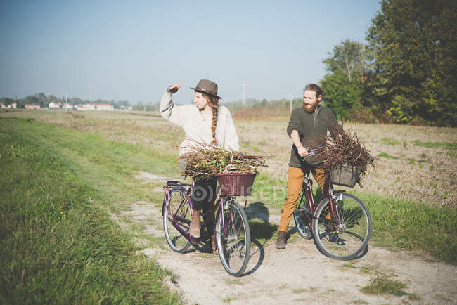Casal jovem ciclismo no campo, Dolo, Veneza, Itália — Fotografia de Stock