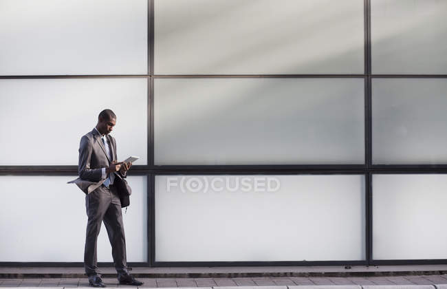 Uomo d'affari che utilizza tablet digitale da edificio per uffici — Foto stock