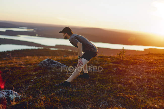 Excursionista estirándose en la naturaleza salvaje, Laponia, Finlandia - foto de stock