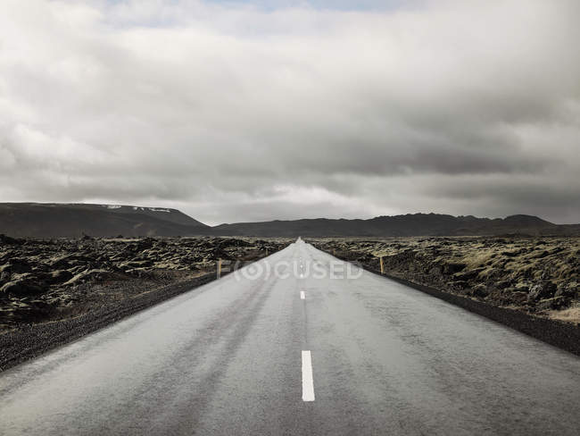 Strada rurale sotto cielo nuvoloso — Foto stock