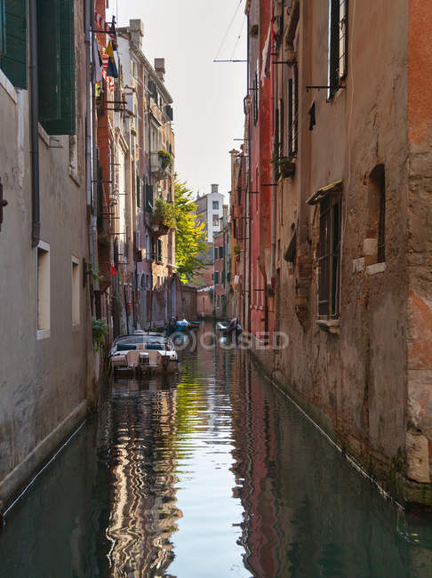 Edificios y botes de remos en el canal urbano - foto de stock