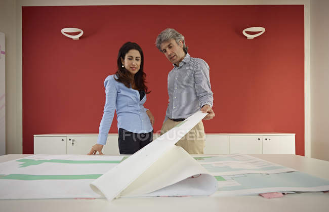 Dos arquitectos con planos en la oficina - foto de stock