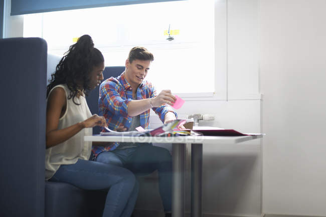 Young female and male college students planning with adhesive notes — Stock Photo