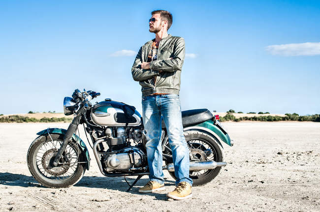 Portrait of young male motorcyclist on arid plain, Cagliari, Sardinia, Italy — Stock Photo