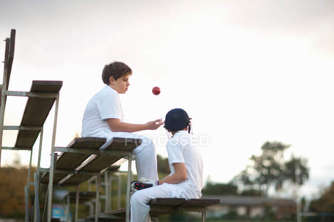 Boys on bleachers at cricket pitch — Stock Photo