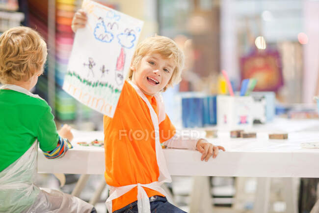 Boy holding up his drawing — Stock Photo