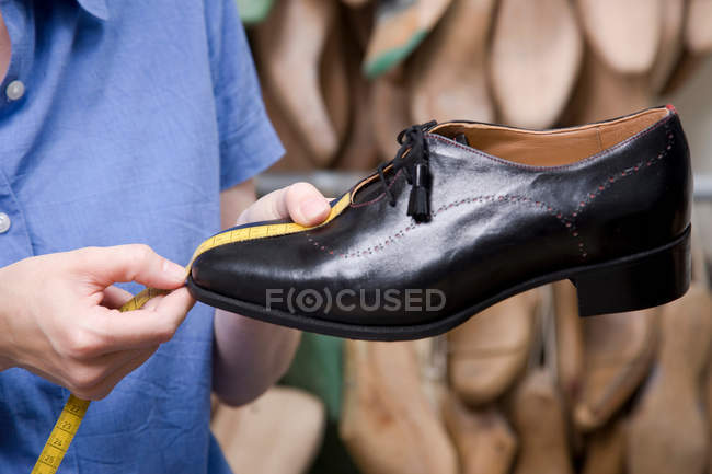 Trabalhador mãos sapatos de medição, close-up — Fotografia de Stock