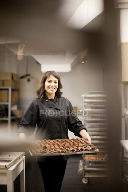 Woman holding tray with chocolate — Stock Photo