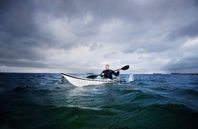 Homem remando em caiaque no oceano — Fotografia de Stock