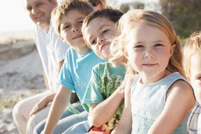 Familie am Strand blickt lächelnd in die Kamera — Stockfoto