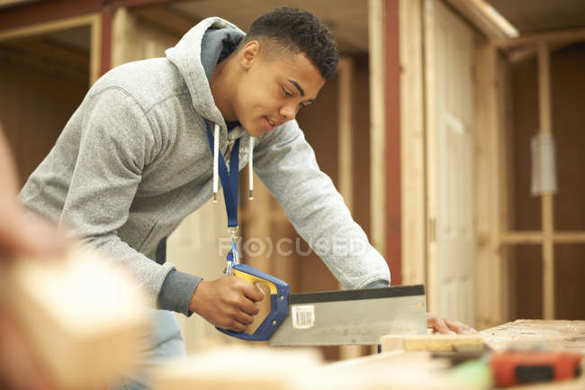 Studente di college maschile utilizzando sega in laboratorio di lavorazione del legno — Foto stock