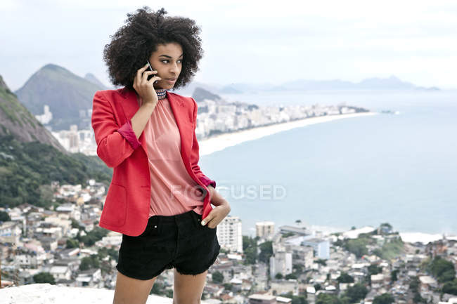 Mujer joven usando teléfono móvil, Casa Alto Vidigal, Rio De Janeiro, Brasil - foto de stock