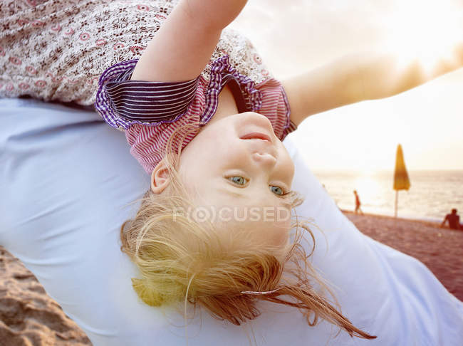 Человек, несущий маленькую девочку на спине, крупный план — стоковое фото